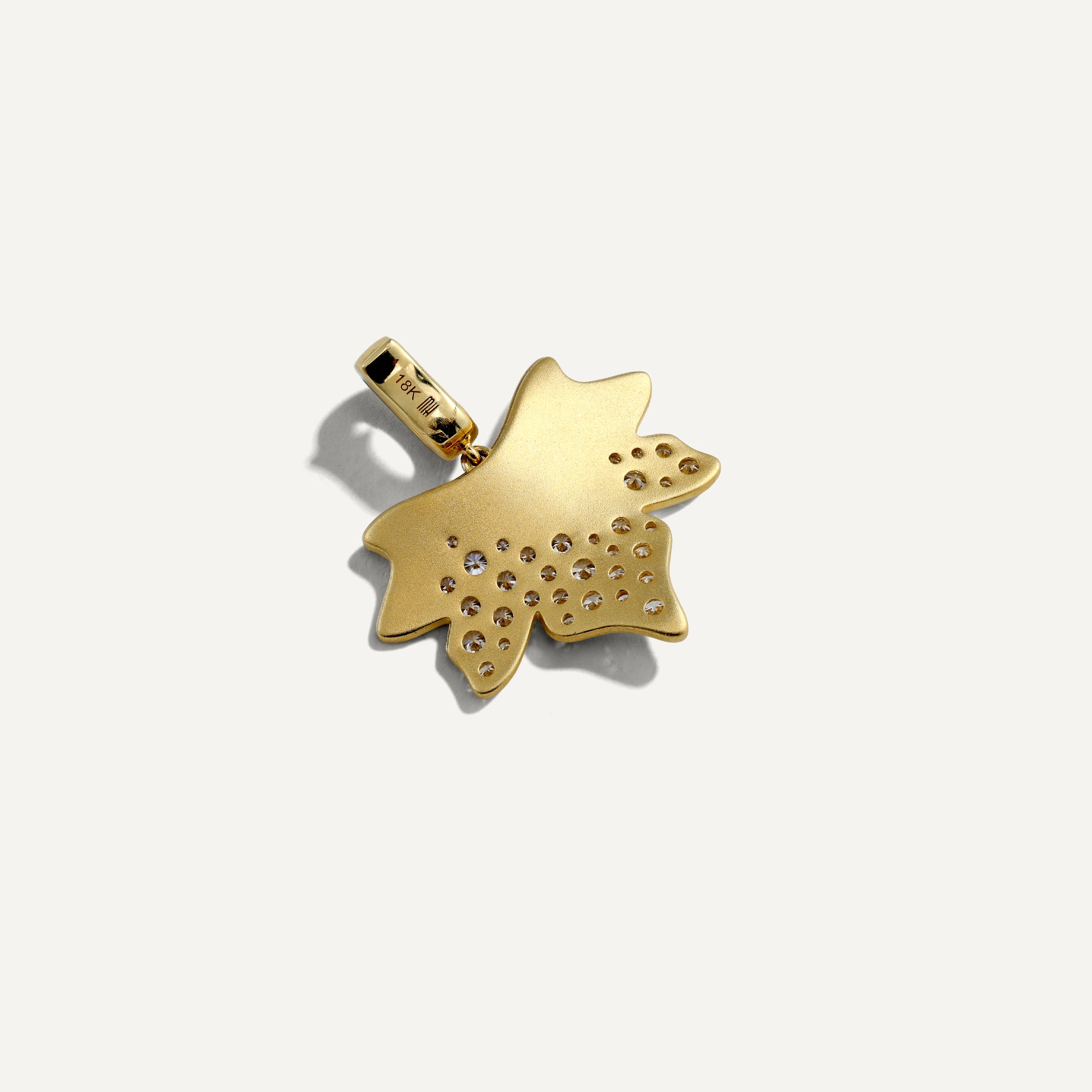 Back of Gold pendant with embedded stones on a white background