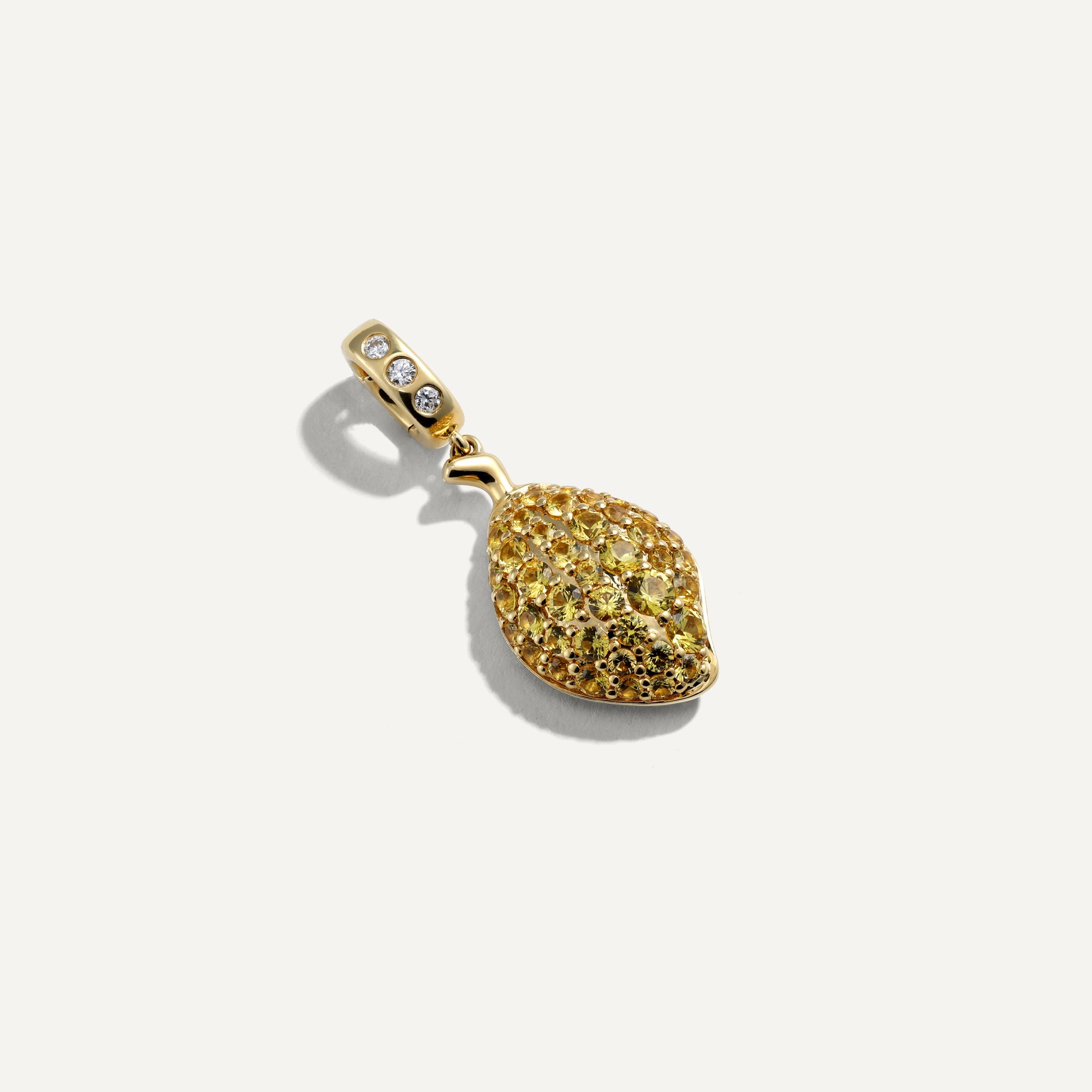 Gold pendant with textured design on a white background