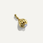Gold pendant with a white stone on a light gray background