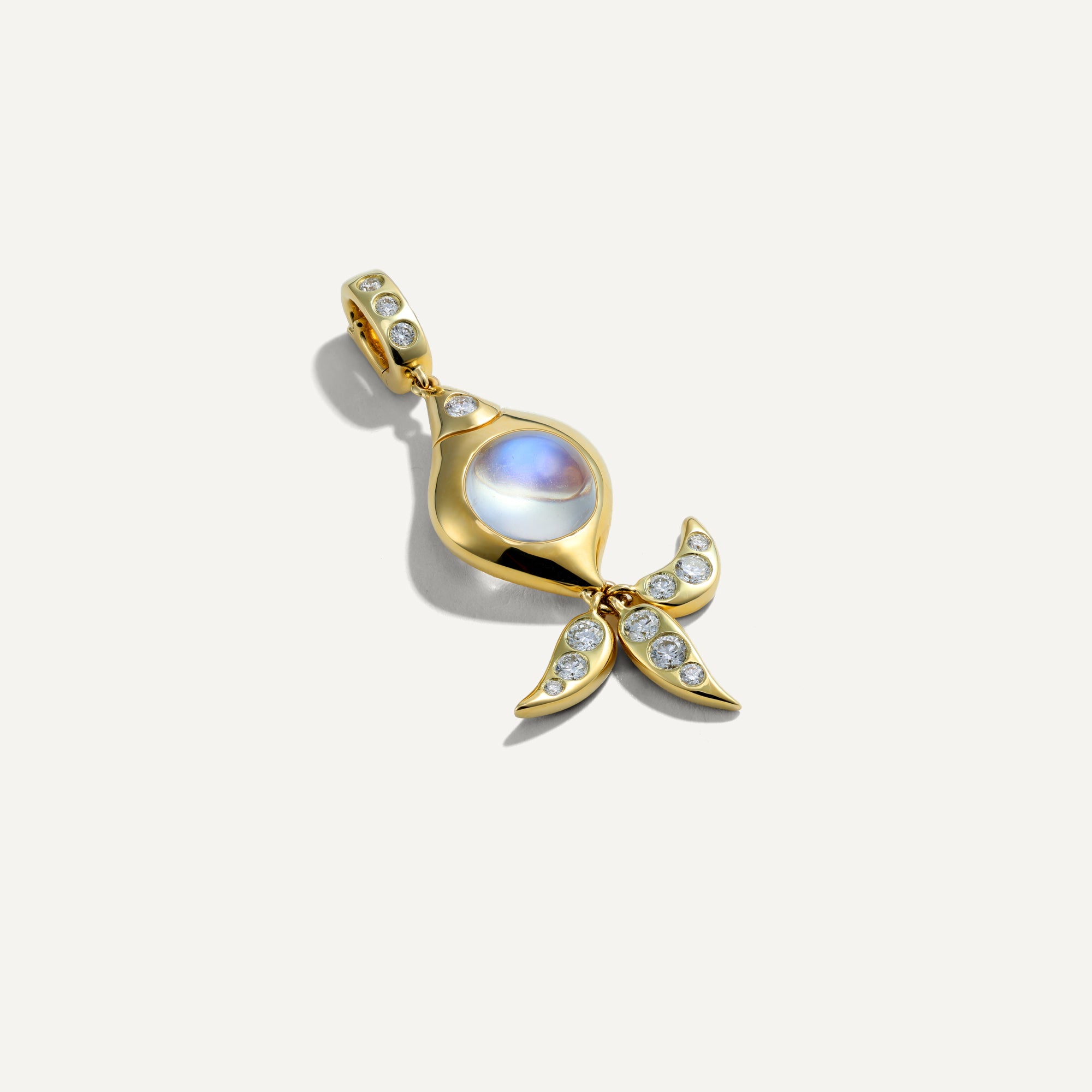 Gold pendant with a central gemstone on a white background