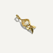 Gold pendant with a central gemstone on a white background