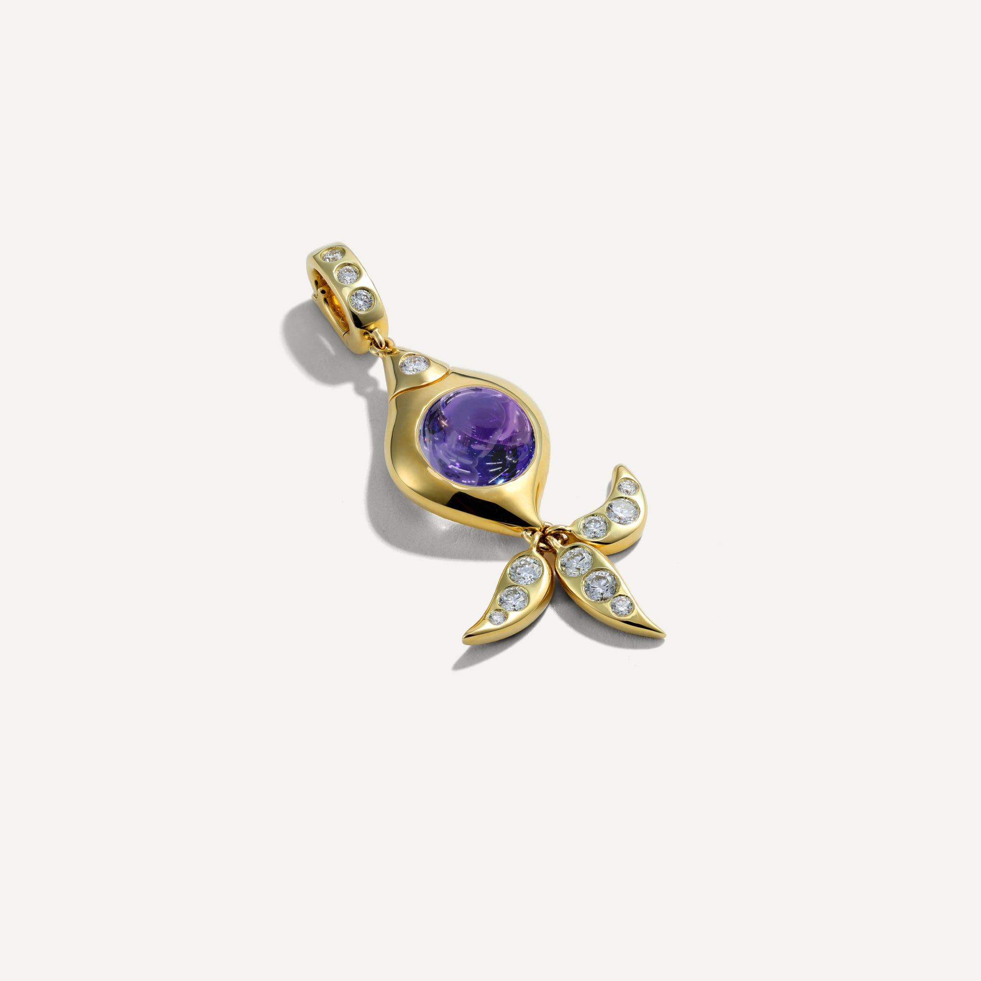 Gold pendant with purple gemstone and diamond accents on a white background