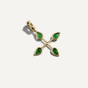 Gold cross-shaped pendant with green gemstones on a white background