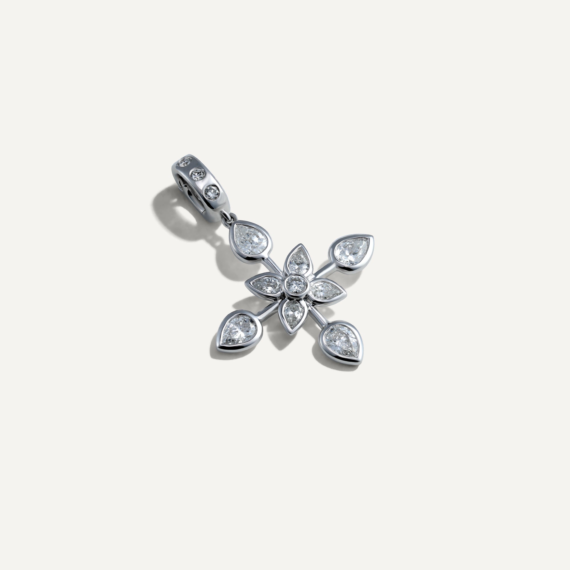 Silver floral pendant with teardrop-shaped gemstones on a light gray background