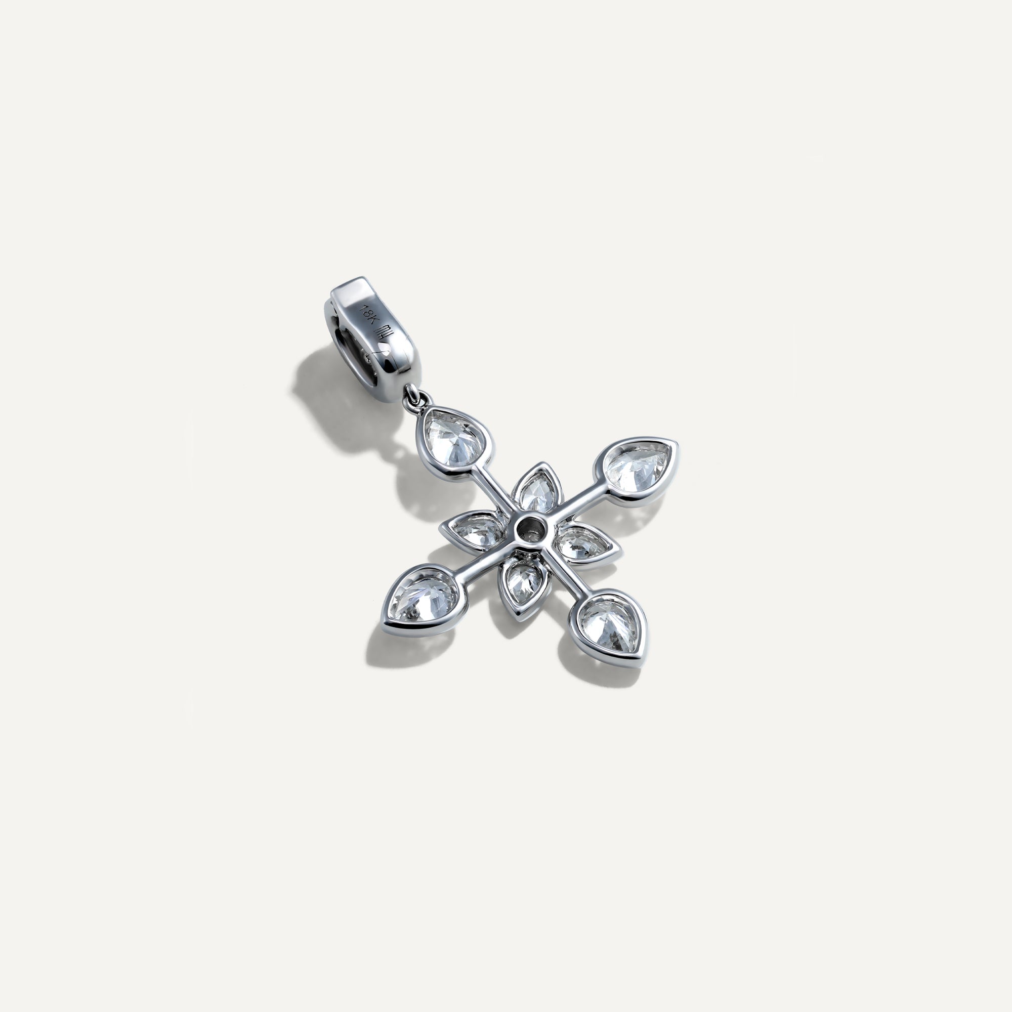 Silver floral pendant with clear gemstones on a light gray background