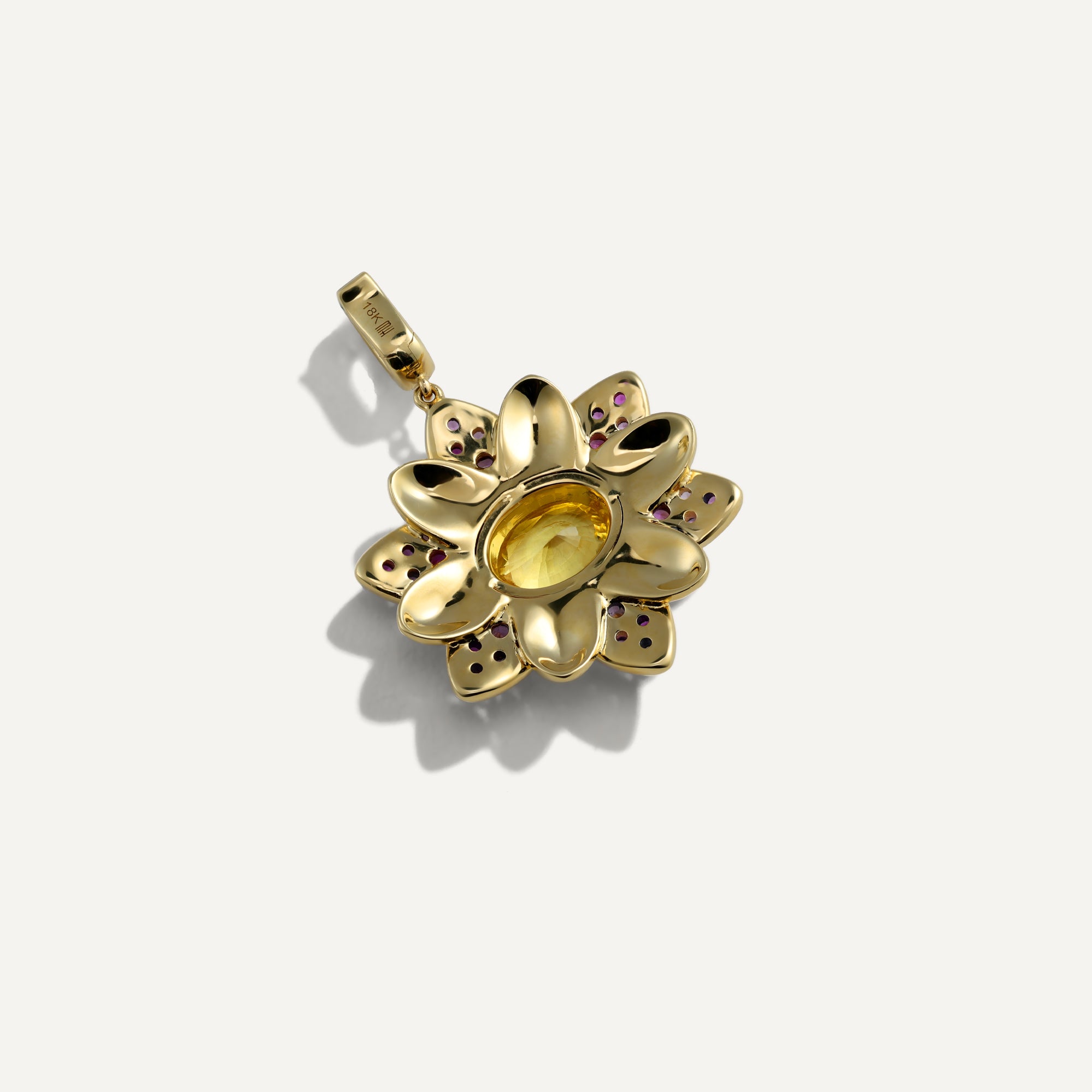 Gold pendant with gemstones on a white background